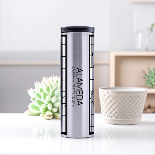 Alameda California Custom City Map Inscription Coordinates on 17oz Stainless Steel Insulated Tumbler in Tactile Lines with Succulent in Background