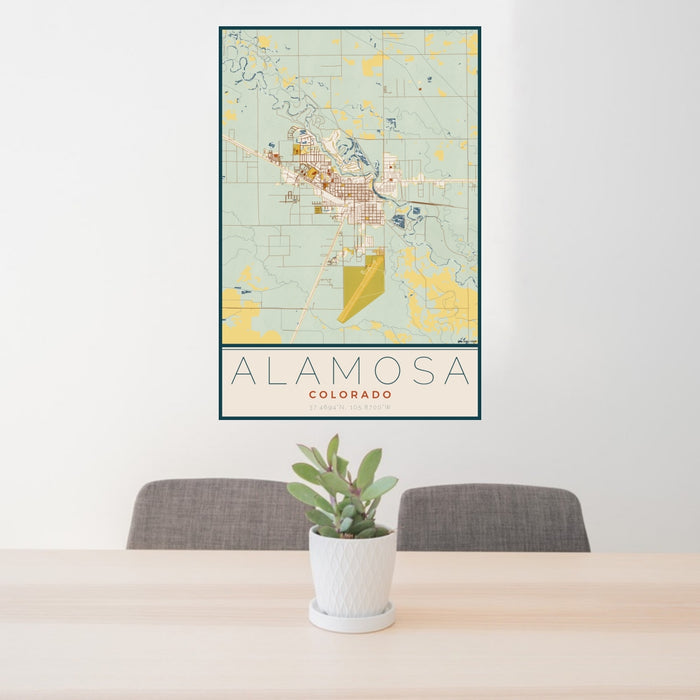 24x36 Alamosa Colorado Map Print Portrait Orientation in Woodblock Style Behind 2 Chairs Table and Potted Plant
