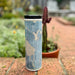 17oz Stainless Steel Insulated Tumbler in White with Custom Afternoon Style Lying on Ground Next to Flowers