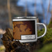 Right View Custom Arcadia Nebraska Map Enamel Mug in Ember on Grass With Trees in Background