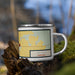 Right View Custom Arcadia Nebraska Map Enamel Mug in Woodblock on Grass With Trees in Background