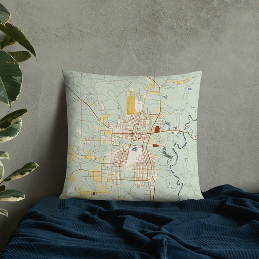Custom Bogalusa Louisiana Map Throw Pillow in Woodblock on Bedding Against Wall