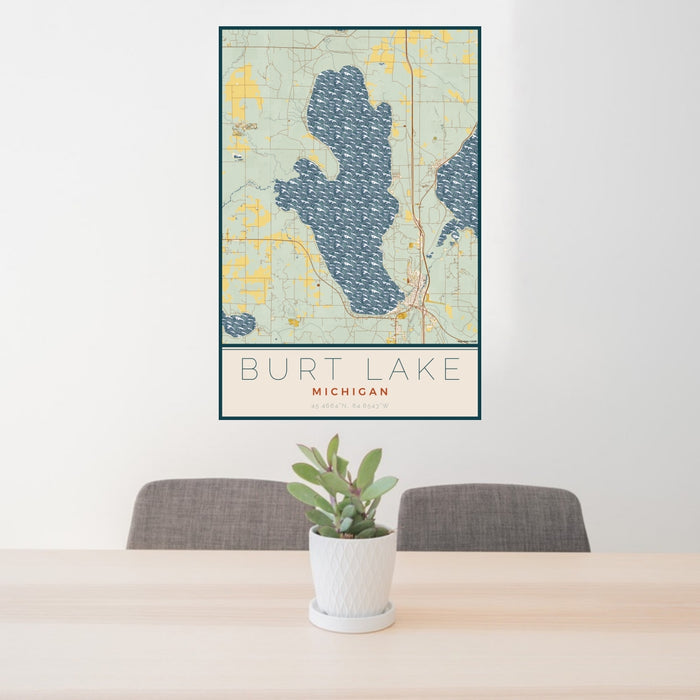 24x36 Burt Lake Michigan Map Print Portrait Orientation in Woodblock Style Behind 2 Chairs Table and Potted Plant