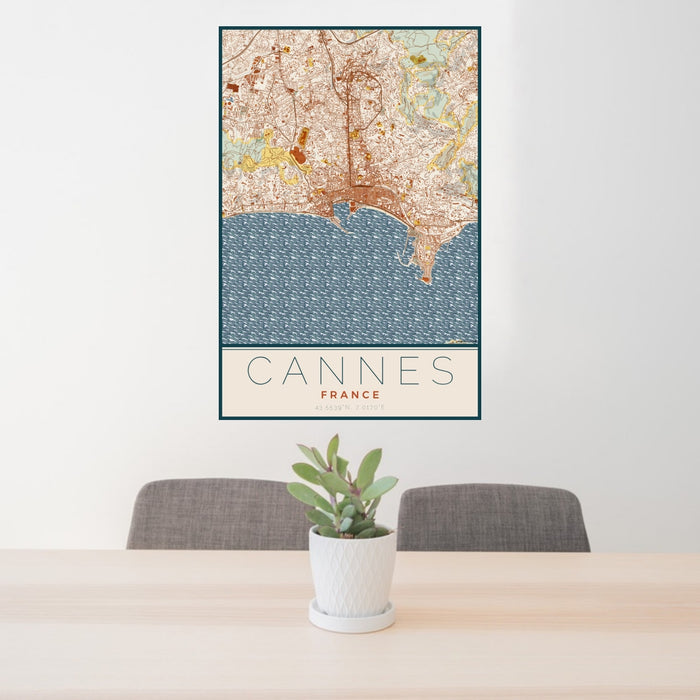 24x36 Cannes France Map Print Portrait Orientation in Woodblock Style Behind 2 Chairs Table and Potted Plant