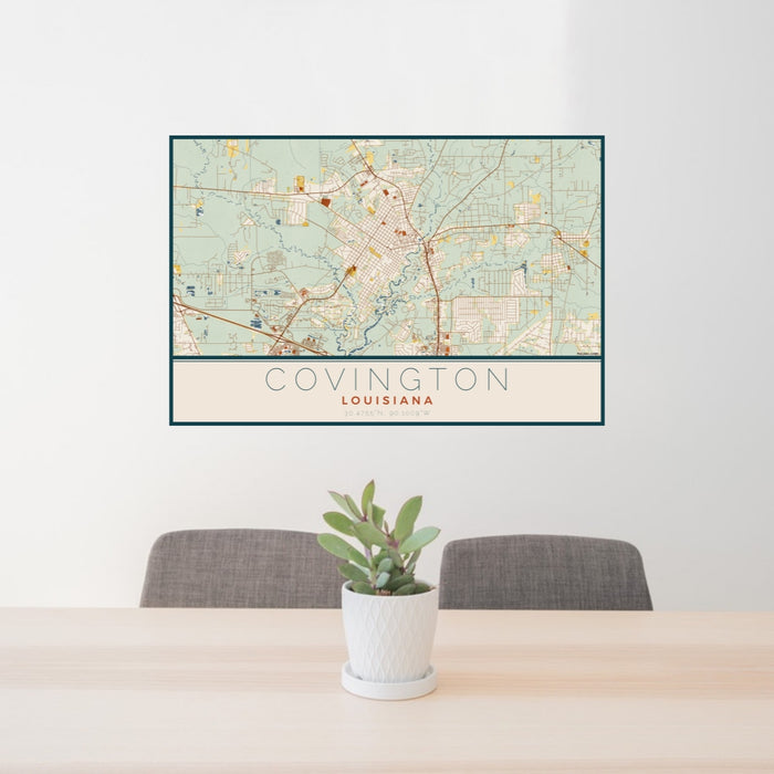 24x36 Covington Louisiana Map Print Lanscape Orientation in Woodblock Style Behind 2 Chairs Table and Potted Plant