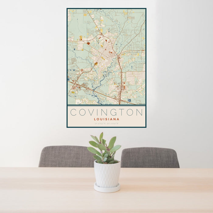 24x36 Covington Louisiana Map Print Portrait Orientation in Woodblock Style Behind 2 Chairs Table and Potted Plant