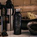 20oz Stainless Steel Insulated Bottle with Bamboo Top in Black with Custom Engraving of Map on Table with Coffee