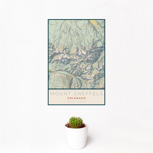12x18 Mount Sneffels Colorado Map Print Portrait Orientation in Woodblock Style With Small Cactus Plant in White Planter