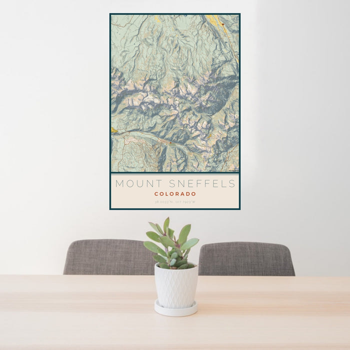 24x36 Mount Sneffels Colorado Map Print Portrait Orientation in Woodblock Style Behind 2 Chairs Table and Potted Plant