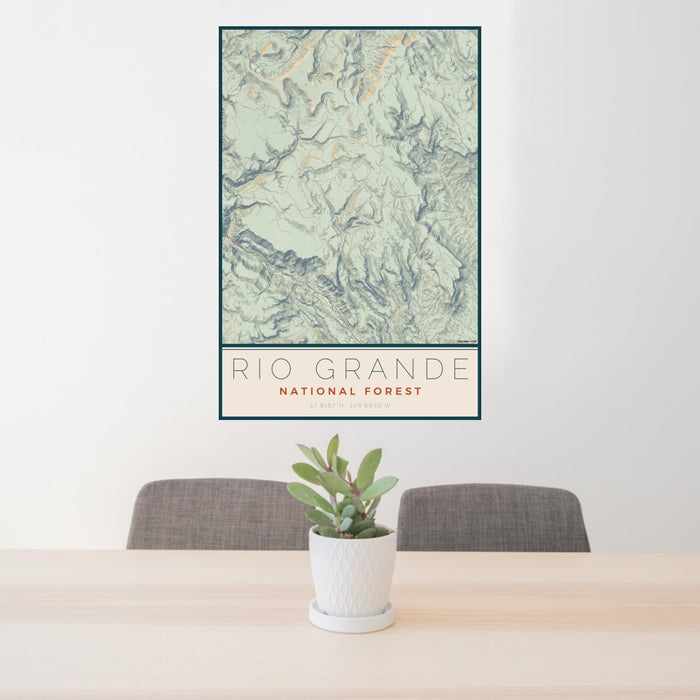 24x36 Rio Grande National Forest Map Print Portrait Orientation in Woodblock Style Behind 2 Chairs Table and Potted Plant