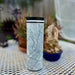 17oz Stainless Steel Insulated Tumbler in White with Custom Classic Style in Hand Against Purple Wall