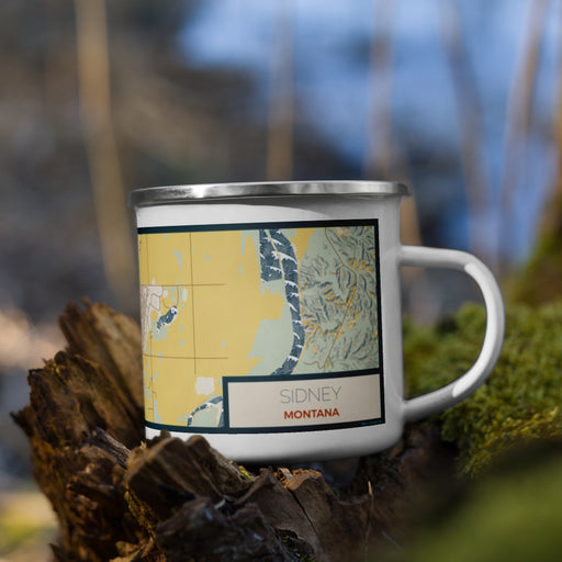 Right View Custom Sidney Montana Map Enamel Mug in Woodblock on Grass With Trees in Background
