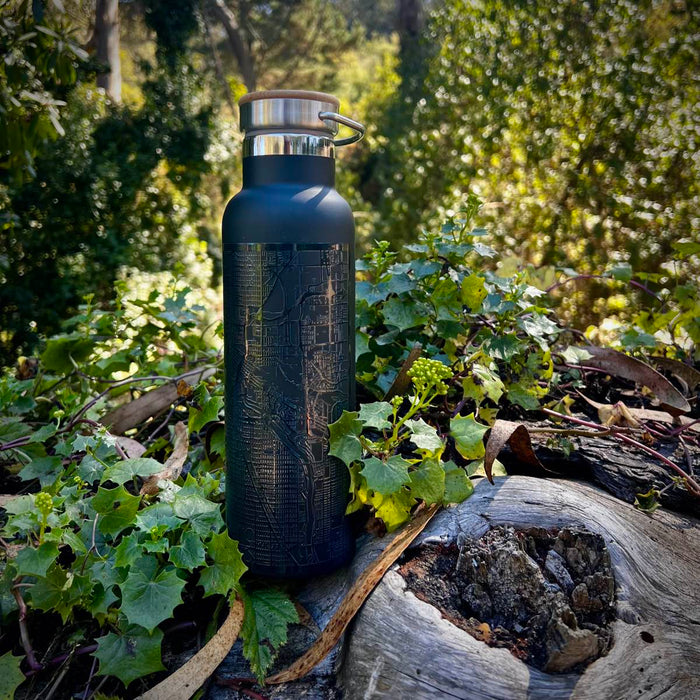 20oz Stainless Steel Insulated Bottle with Bamboo Top in Black in forrest setting