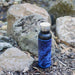 20oz Stainless Steel Insulated Bottle with Bamboo Top in Black with Blue Map next to rocks