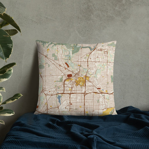 Custom Akron Ohio Map Throw Pillow in Woodblock on Bedding Against Wall