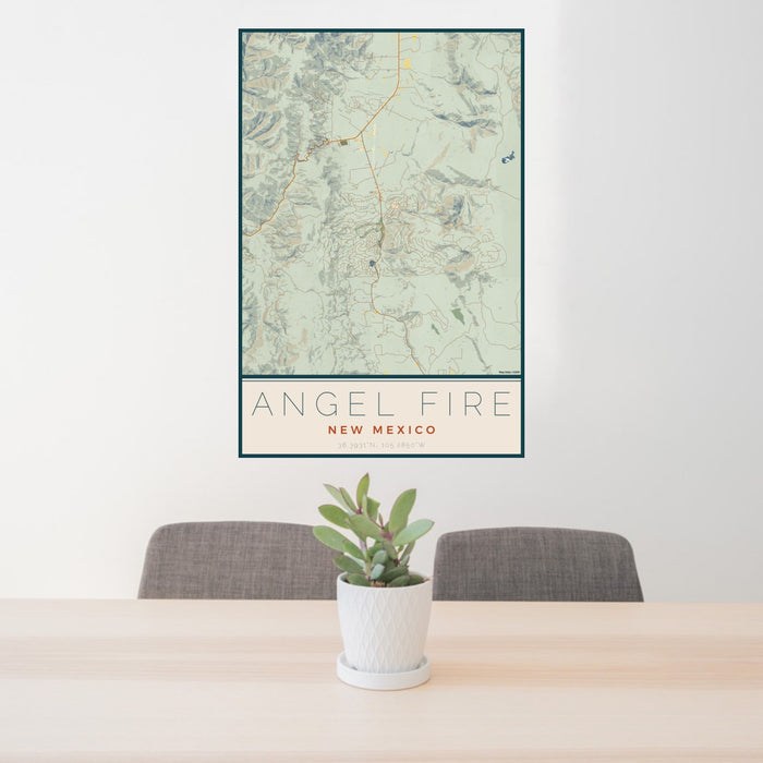 24x36 Angel Fire New Mexico Map Print Portrait Orientation in Woodblock Style Behind 2 Chairs Table and Potted Plant