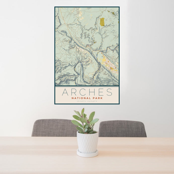 24x36 Arches National Park Map Print Portrait Orientation in Woodblock Style Behind 2 Chairs Table and Potted Plant