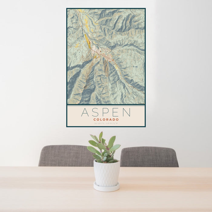 24x36 Aspen Colorado Map Print Portrait Orientation in Woodblock Style Behind 2 Chairs Table and Potted Plant