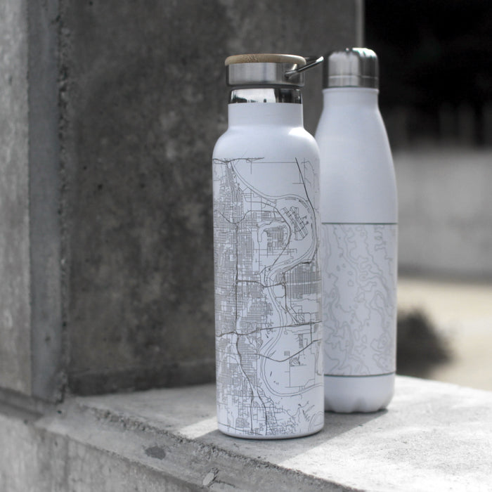 20oz Stainless Steel Insulated Bottle with Bamboo Top in White with Custom Engraving of Map in Front of Concrete Wall
