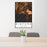 24x36 Bigfork Montana Map Print Portrait Orientation in Ember Style Behind 2 Chairs Table and Potted Plant
