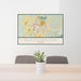 24x36 Bloomington Indiana Map Print Landscape Orientation in Woodblock Style Behind 2 Chairs Table and Potted Plant