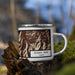 Right View Custom Borah Peak Idaho Map Enamel Mug in Ember on Grass With Trees in Background
