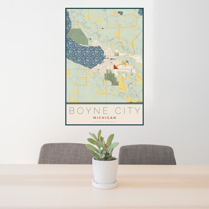 24x36 Boyne City Michigan Map Print Portrait Orientation in Woodblock Style Behind 2 Chairs Table and Potted Plant