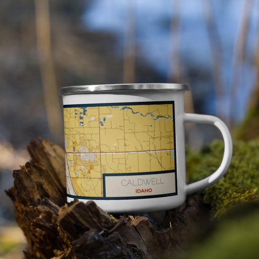 Right View Custom Caldwell Idaho Map Enamel Mug in Woodblock on Grass With Trees in Background