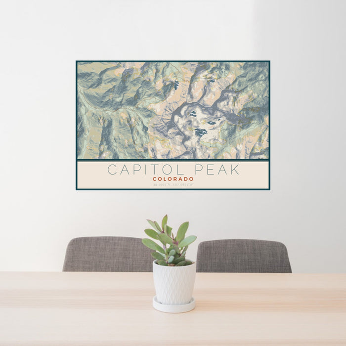 24x36 Capitol Peak Colorado Map Print Lanscape Orientation in Woodblock Style Behind 2 Chairs Table and Potted Plant