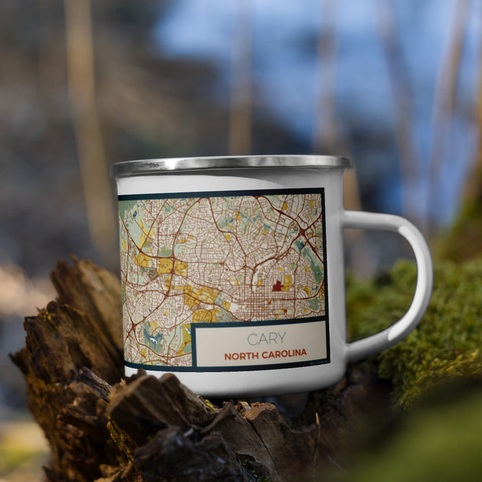 Right View Custom Cary North Carolina Map Enamel Mug in Woodblock on Grass With Trees in Background