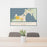 24x36 Charlevoix Michigan Map Print Landscape Orientation in Woodblock Style Behind 2 Chairs Table and Potted Plant