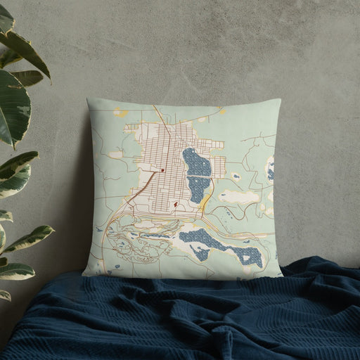Custom Chisholm Minnesota Map Throw Pillow in Woodblock on Bedding Against Wall