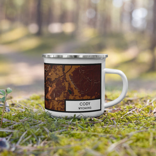 Right View Custom Cody Wyoming Map Enamel Mug in Ember on Grass With Trees in Background