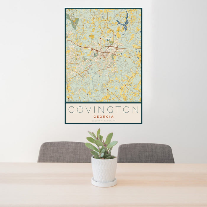 24x36 Covington Georgia Map Print Portrait Orientation in Woodblock Style Behind 2 Chairs Table and Potted Plant