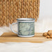 Left View Custom Creede Colorado Map Enamel Mug in Woodblock on Table Top