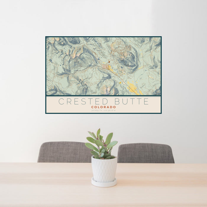 24x36 Crested Butte Colorado Map Print Lanscape Orientation in Woodblock Style Behind 2 Chairs Table and Potted Plant