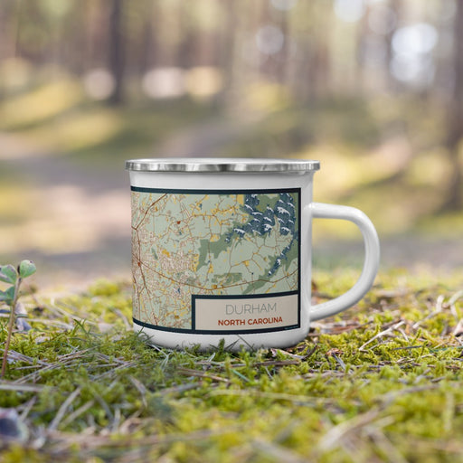 Right View Custom Durham North Carolina Map Enamel Mug in Woodblock on Grass With Trees in Background