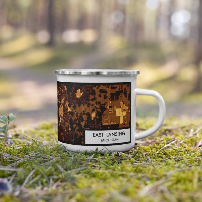 Right View Custom East Lansing Michigan Map Enamel Mug in Ember on Grass With Trees in Background