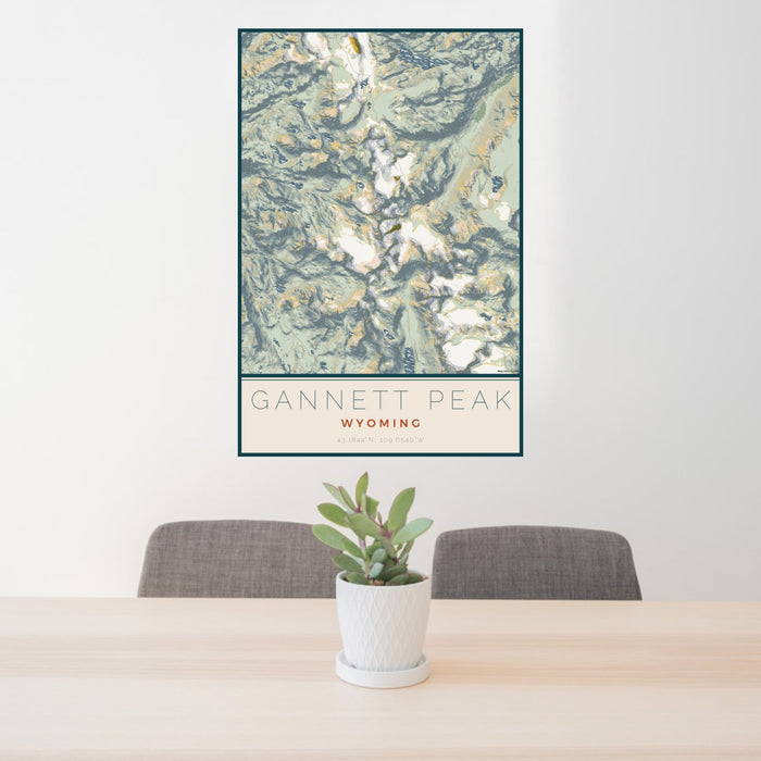 24x36 Gannett Peak Wyoming Map Print Portrait Orientation in Woodblock Style Behind 2 Chairs Table and Potted Plant