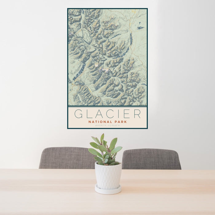 24x36 Glacier National Park Map Print Portrait Orientation in Woodblock Style Behind 2 Chairs Table and Potted Plant