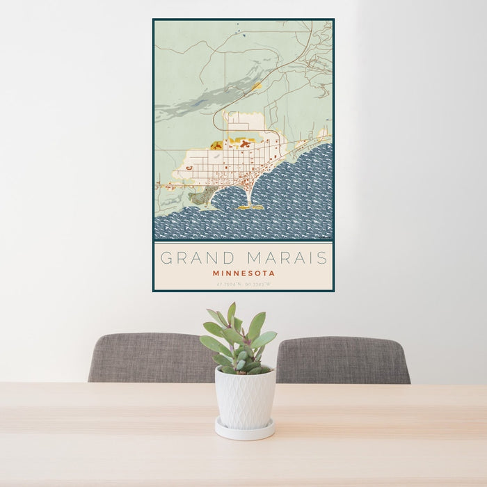 24x36 Grand Marais Minnesota Map Print Portrait Orientation in Woodblock Style Behind 2 Chairs Table and Potted Plant