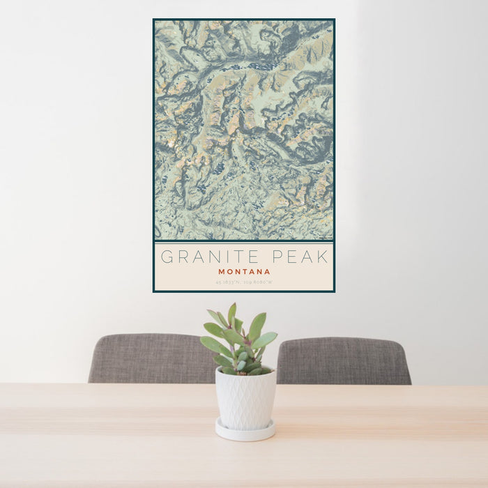 24x36 Granite Peak Montana Map Print Portrait Orientation in Woodblock Style Behind 2 Chairs Table and Potted Plant