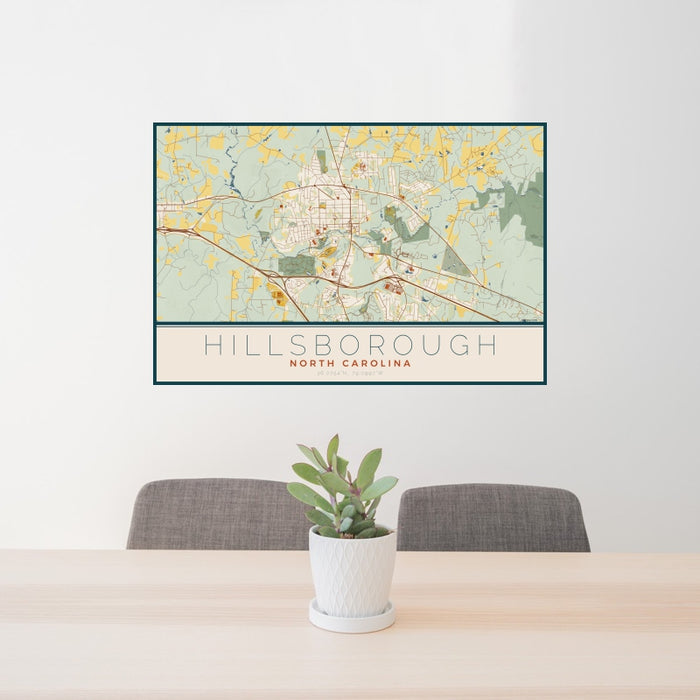 24x36 Hillsborough North Carolina Map Print Landscape Orientation in Woodblock Style Behind 2 Chairs Table and Potted Plant