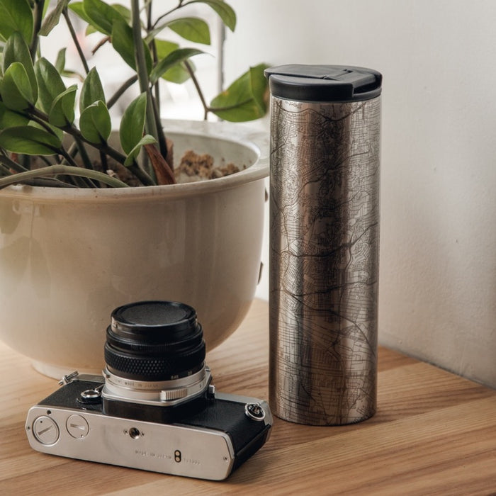 17oz Stainless Steel Insulated Tumbler with Custom Engraving of Map on Table Next to Camera and Plant