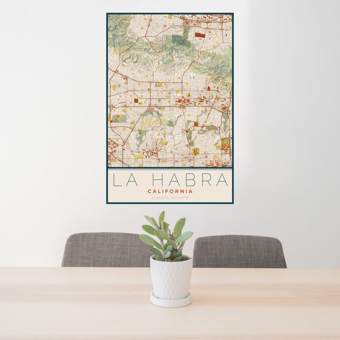 24x36 La Habra California Map Print Portrait Orientation in Woodblock Style Behind 2 Chairs Table and Potted Plant