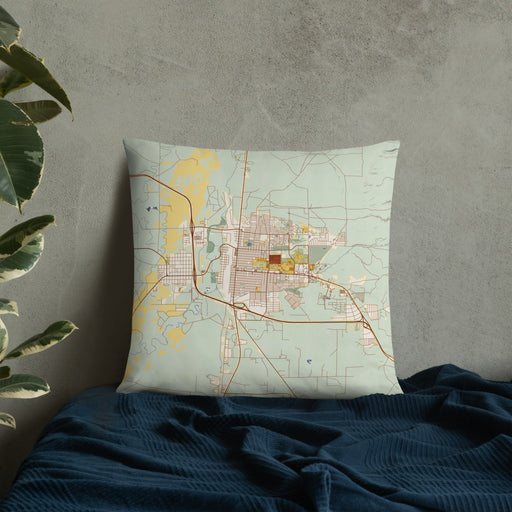 Custom Laramie Wyoming Map Throw Pillow in Woodblock on Bedding Against Wall