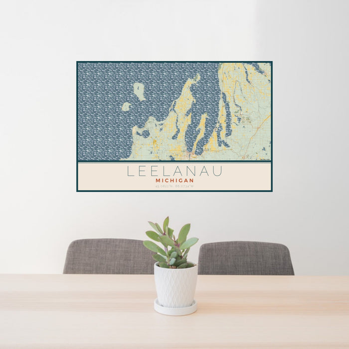 24x36 Leelanau Michigan Map Print Lanscape Orientation in Woodblock Style Behind 2 Chairs Table and Potted Plant