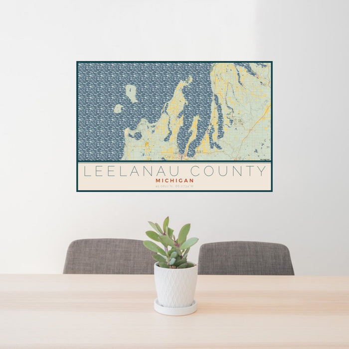 24x36 Leelanau County Michigan Map Print Lanscape Orientation in Woodblock Style Behind 2 Chairs Table and Potted Plant