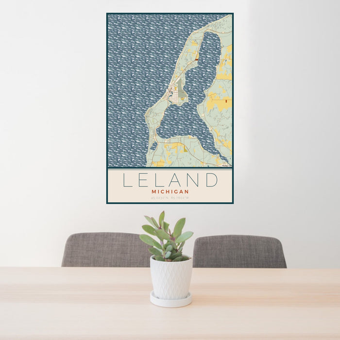 24x36 Leland Michigan Map Print Portrait Orientation in Woodblock Style Behind 2 Chairs Table and Potted Plant