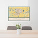 24x36 Longmont Colorado Map Print Landscape Orientation in Woodblock Style Behind 2 Chairs Table and Potted Plant